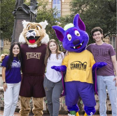 ACC mascot R.B., and Texas State mascot pose for a group shot with students who transfered from ACC to Texas State.